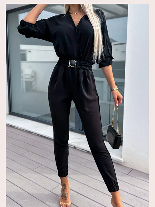 Sofistikerad svart jumpsuit med minimalistisk vändbar krage