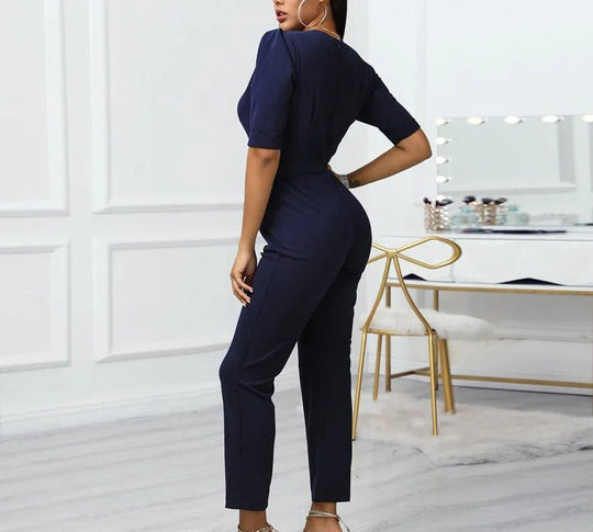 Elegant blå V-halsad jumpsuit med metallspänne och smala byxor