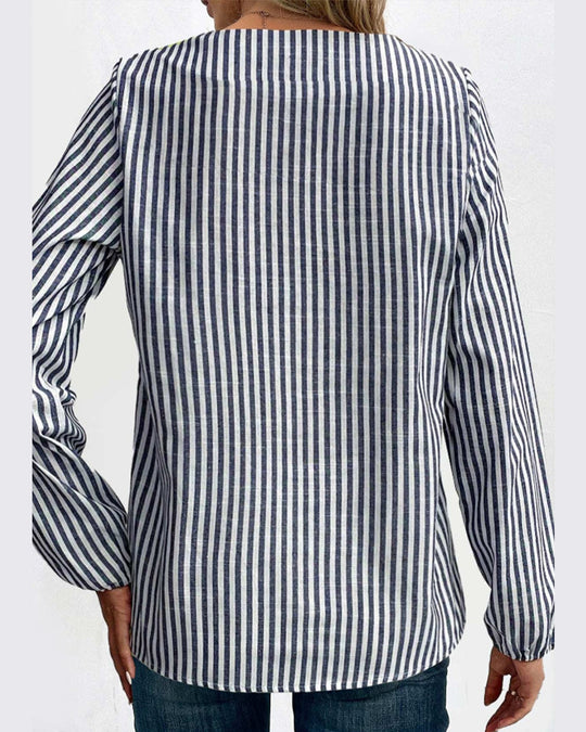 Blus med randigt mönster och asymmetrisk krage